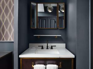 a bathroom with a sink and a mirror at Hotel Phillips Kansas City, Curio Collection By Hilton in Kansas City