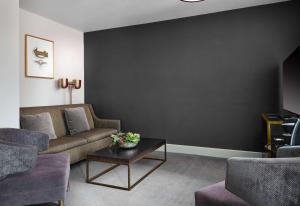a living room with a couch and a table at Hotel Phillips Kansas City, Curio Collection By Hilton in Kansas City