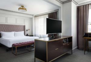 a hotel room with a bed and a flat screen tv at Hotel Phillips Kansas City, Curio Collection By Hilton in Kansas City