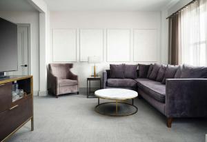 a living room with a couch and a table at Hotel Phillips Kansas City, Curio Collection By Hilton in Kansas City