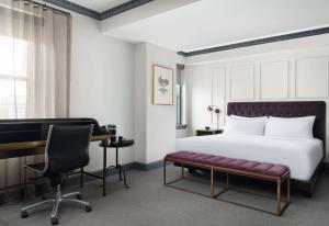a bedroom with a bed and a desk and a chair at Hotel Phillips Kansas City, Curio Collection By Hilton in Kansas City
