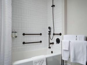 a white bathroom with a tub and towels at Hotel Phillips Kansas City, Curio Collection By Hilton in Kansas City