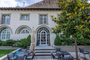an exterior view of a house with chairs and an umbrella at Dimora Palanca Boutique & SPA in Florence