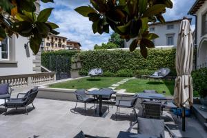 a patio with tables and chairs and a garden at Dimora Palanca Boutique & SPA in Florence