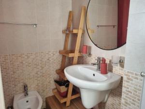 a bathroom with a sink and a mirror and a toilet at La Tana del Bianconiglio in Ostuni