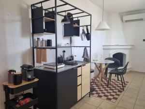a kitchen with a counter and a table in a room at La Tana del Bianconiglio in Ostuni +14 photos