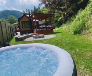 a hot tub in a yard with a gazebo at Budget izba pre veľkú rodinu alebo skupinu priateľov in ľubochňa