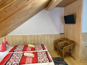 a bedroom with two beds and a tv in a room at Budget izba pre veľkú rodinu alebo skupinu priateľov in ľubochňa