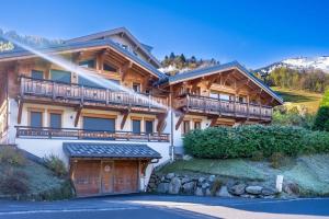 ein großes Holzhaus mit Balkon und Garage in der Unterkunft Les Trabets - Bellevue telecabine - Renove in Les Houches