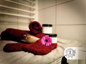 a red towel with a pink flower and two medicines at Apartament Państwa Marszał in Radomsko