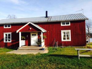 a red house with a white door and a bench at Hus i Lappland in Harads