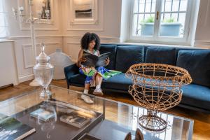 a young girl sitting on a couch reading a book at Dimora Palanca Boutique & SPA in Florence