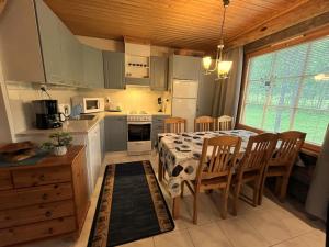 a kitchen with a table and chairs and a kitchen with white cabinets at Lapland Cabin Levi in Kittilä