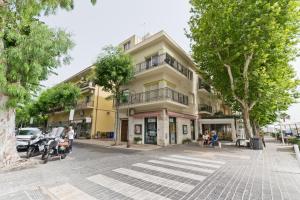 a yellow building on a city street with trees at Casa Soleil in Francavilla al Mare