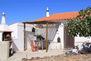 a table and chairs in front of a white house at Casa Papoula in Tavira