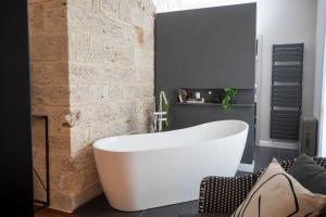 a white bath tub in a bathroom with a brick wall at Dimora Storica Nella Torre Bed & Breakfast in Ascoli Piceno +40 photos