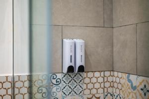 Dos cepillos de dientes eléctricos en una pared de un baño. en Baron’s Suites, en Palermo 54 fotos más