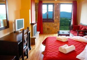 a bedroom with a red bed with a desk and a couch at Zagori Philoxenia Hotel in Monodendri