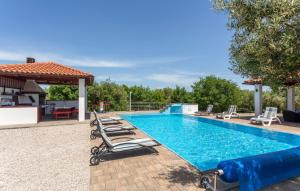 basen z leżakami obok niego w obiekcie Villa With Pool, Jacuzzi, Sauna, Fitness, Playground & Wine Cellar w mieście Gostinjac