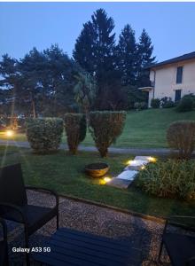 a garden with a bench and lights in the grass at Ina in Lavena Ponte Tresa