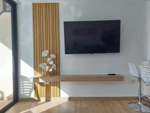 a living room with a flat screen tv on a wall at Deluxe Apart Castle Harbour in Los Cristianos +27 photos