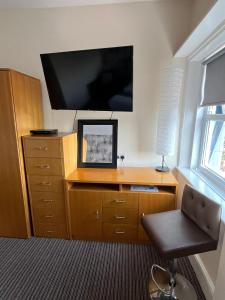 a room with a desk with a tv and a chair at The New Brighton Hotel in New Brighton