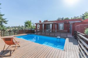 a swimming pool on a deck with a house at La Villetta nel Parco in La Giustiniana