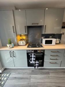 a kitchen with a stove and a microwave at Number 70, Portobello, Edinburgh in Edinburgh +19 photos