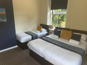 a hotel room with two beds and a window at The New Brighton Hotel in New Brighton