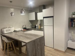 a kitchen with a table and a white refrigerator at ENCANTO CUENCA Balcones De La Historia in Cuenca