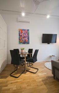 une salle à manger avec des chaises, une table et une télévision dans l'établissement Apartament SUNNY Przy Rynku z klimatyzacją i parkingiem, à Kielce