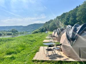 a row of tents lined up next to a river at Stern-Kuppelzelt in Beverungen