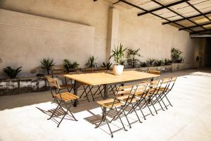 a wooden table and chairs in a room with plants at Villa Donas in Martín Muñoz de las Posadas