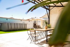 a patio with a table and chairs and an umbrella at Villa Donas in Martín Muñoz de las Posadas