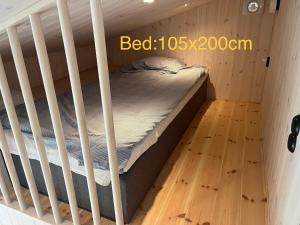 a bed in a crib in a room with a wooden floor at Mysigt attefallshus med närhet till stad och hav in Västra Frölunda +8 photos