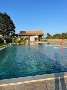 a woman walking on a surfboard in a pool of water at Sonhos da Serra - apartamento 201 - A in Bananeiras