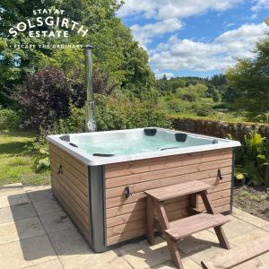 a wooden bath tub with a wooden bench and a chair at The Farmhouse at Solsgirth Home Farm in Dollar +14 photos