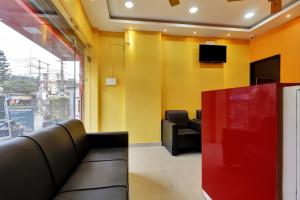 a waiting room with a couch and a tv at Capital O H K Residency in Dispur