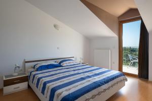 Un dormitorio con una cama y una ventana grande. en Villa Arco, en Svetvinčenat