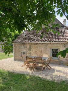 a table and chairs in front of a building at Maison de vacances in Gilly-lès-Cîteaux