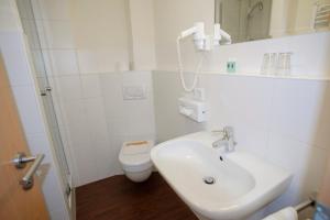 Landgasthof Linde في ديغينهاوسيرتال: حمام أبيض مع حوض ومرحاض