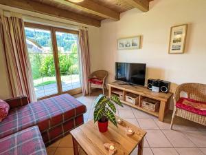 a living room with a couch and a flat screen tv at Holiday Home Chalet Chiemsee by Interhome in Sachrang