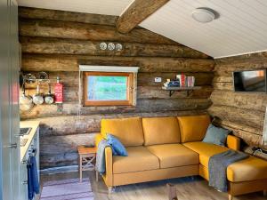 eine Couch in einem Wohnzimmer mit Holzwänden in der Unterkunft Holiday Home Keloveska by Interhome in Ruka