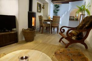 a living room with a chair and a tv at Casa Mona- Andalucian mountain village getaway in Güéjar-Sierra