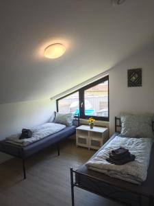 a living room with two beds and a window at Villa Levilia in Strullendorf