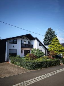 une maison blanche sur le côté d'une rue dans l'établissement Villa Levilia, à Strullendorf