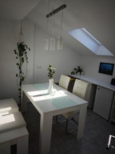 une salle à manger blanche avec une table et des chaises blanches dans l'établissement Villa Levilia, à Strullendorf