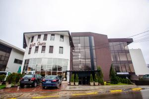 un bâtiment avec des voitures garées devant lui dans l'établissement Hotel Charter Otopeni, à Otopeni