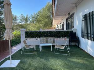 un patio con tavolo, sedie e ombrellone di Casa rural la forilla a Ruidera