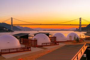 a group of domes with a bridge in the background at GlampDome Shimonoseki in Maeda +6 photos